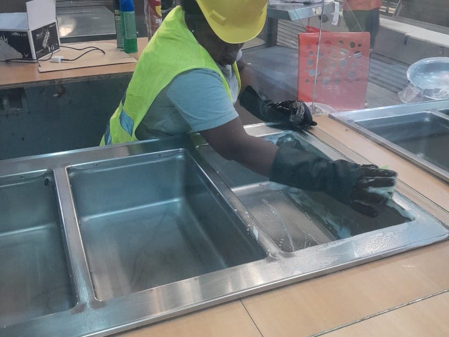 Technicien TropiClean nettoyant un plan de travail en inox