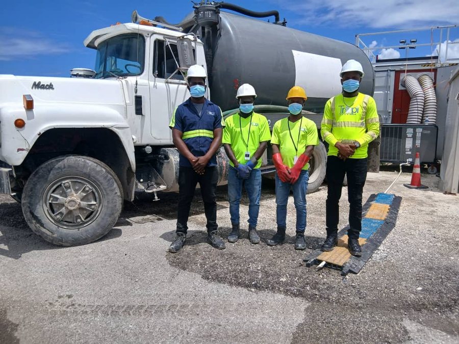 Équipe TropiClean en équipement de protection devant le camion de vidange