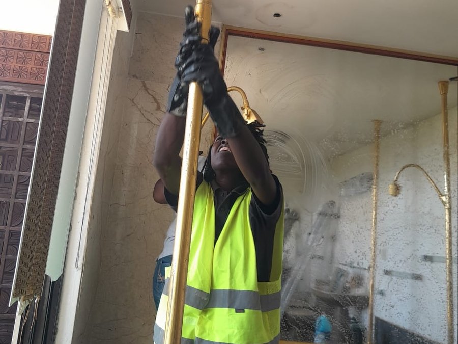 Employé TropiClean nettoyant en hauteur à l'intérieur d'un bâtiment