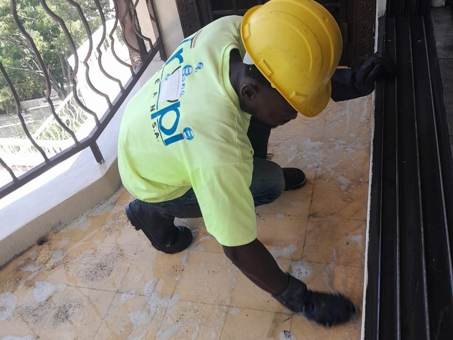 Employé TropiClean nettoyant un seuil et une baie vitrée