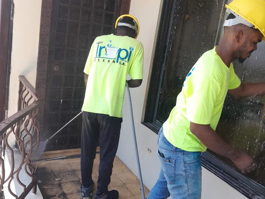 Deux employés TropiClean nettoyant les vitres d'un bâtiment