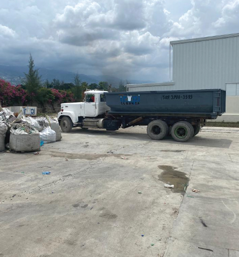 Camion benne TropiClean chargeant des sacs de déchets