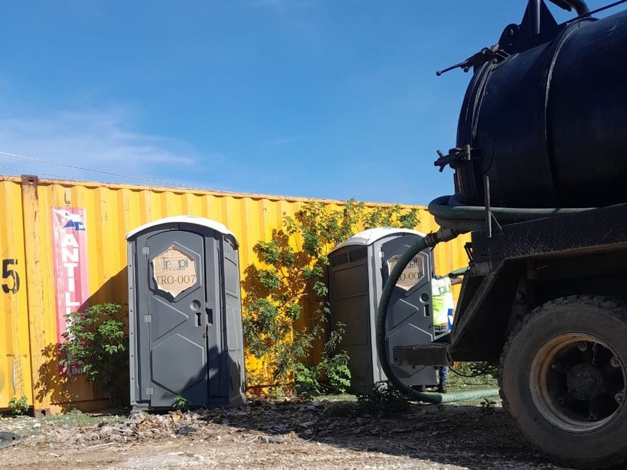 Camion de vidange et toilette portable TropiClean sur un chantier